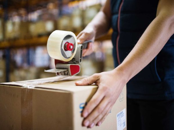 male-warehouse-worker-sealing-cardboard-boxes-PSKUTTE